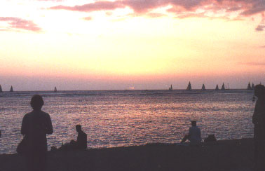 The sun drops behind the clouds as the sailboats race out to watch