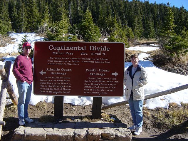 James and Julie on either side of as sign marking the continental devide