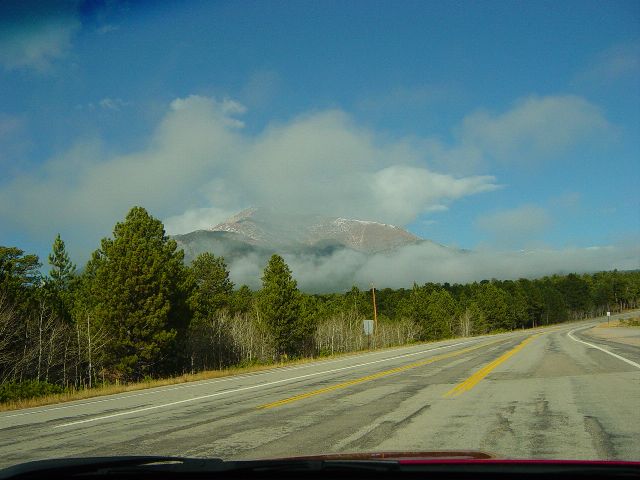 Clouds breaking up allowing view of mountain peaks