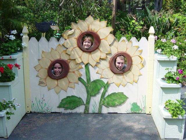 Three people show their faces through flower cutouts