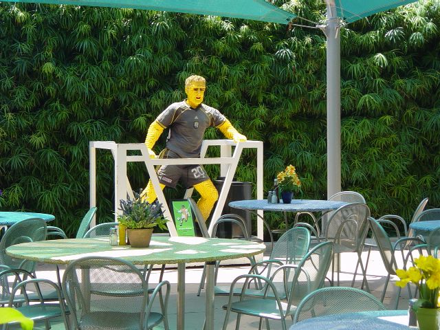 Tables and chairs around a life size soccer player made with LEGO
