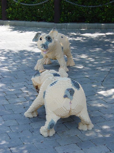 Two pigs made of LEGO standing on the sidewalk