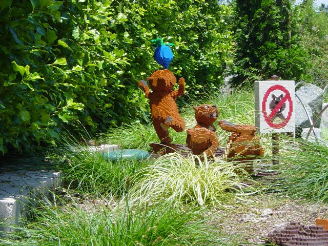 Three LEGO gophers play near a no-gophers sign