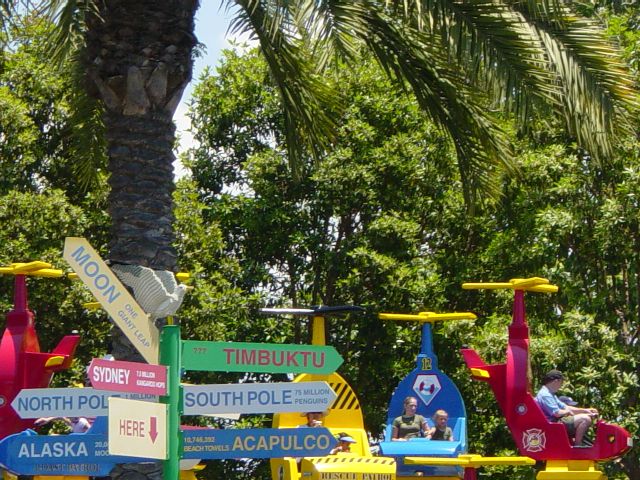 A sign directs people to Timbuktu, north or south pole, Sydney Australia, and the moon