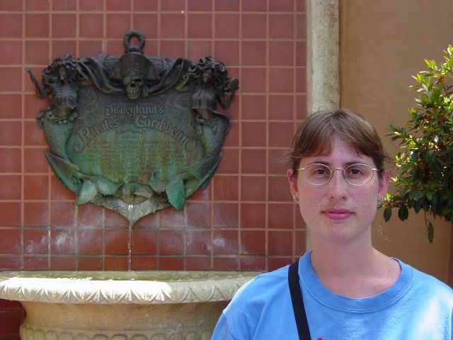 Julie next to an ornate fountain on a red tile wall