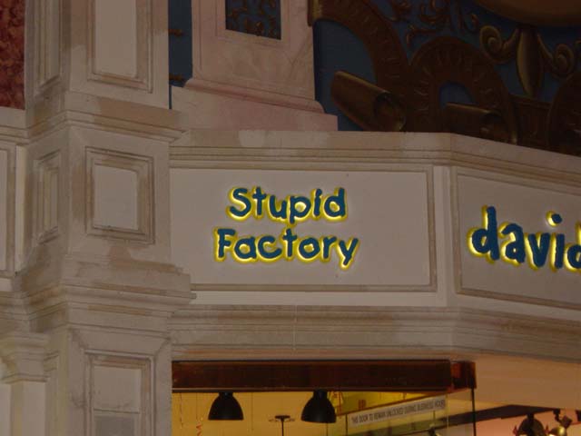 Sign above a store entry reading stupid factory