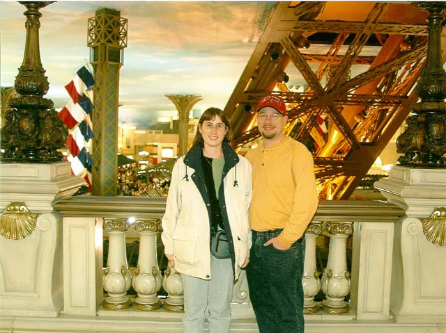 James nad Julie inside the Paris hotel with the base of the Eiffel Tower beyond