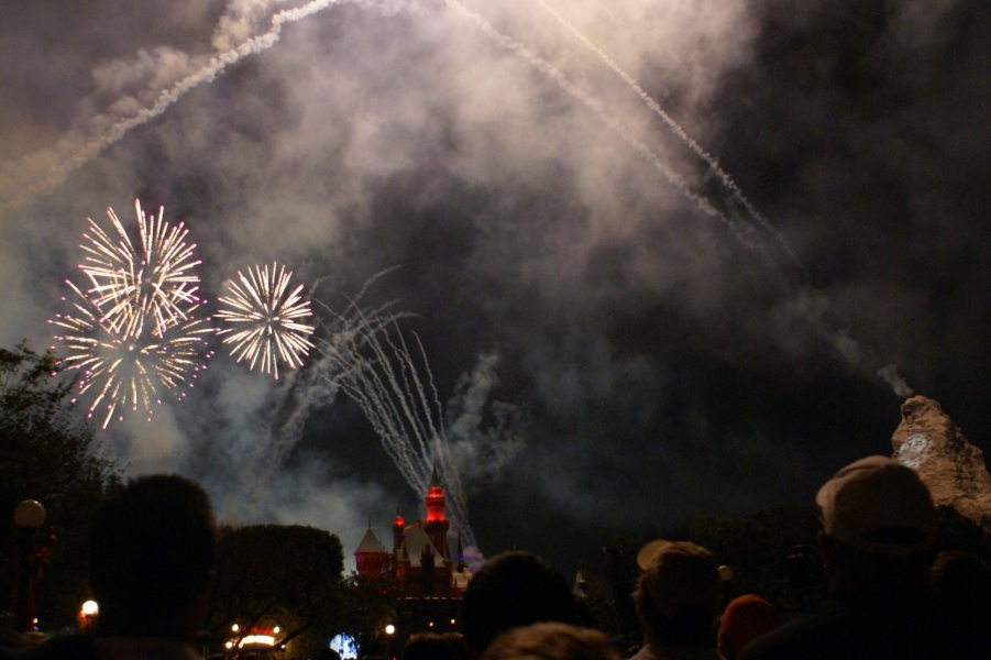 White fireworks light up the smoke above the castle lit in red
