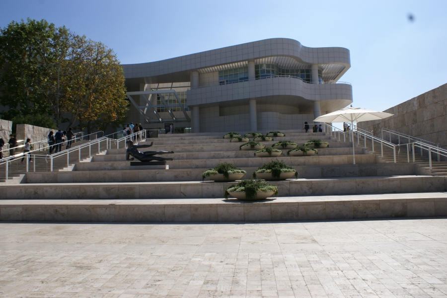 Large outdoor stairs lead to a white building with a curved exterior
