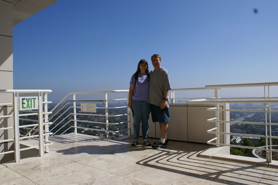 James and Julie stand by a railing with Los Angeles visible in the distance