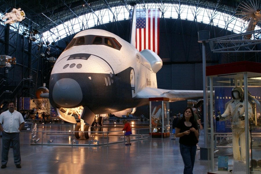 A white space shuttle with black bottom with a ramp so visitors can see the inside
