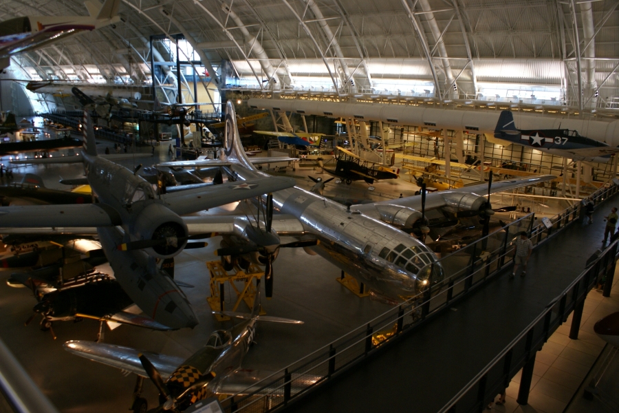 A large silver airplane with 4 engines sits amongst smaller craft