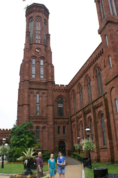 An octagonal red brick tower extends above a two-story building with ornate detailing of the same color brick