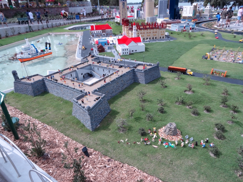 A gray fort with pointed bastions at each corner made of LEGO sets near a waterway