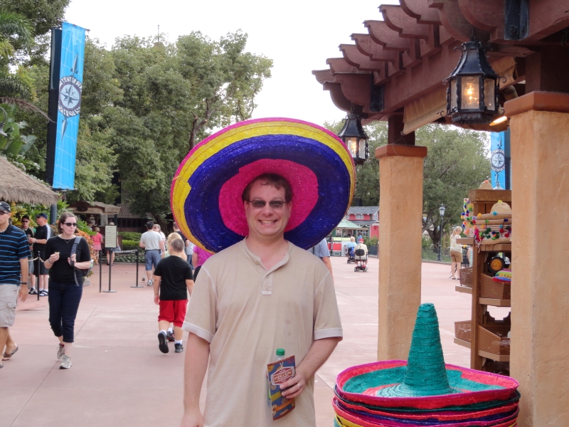 James wearing a large pink, blue, and yellow sombrero