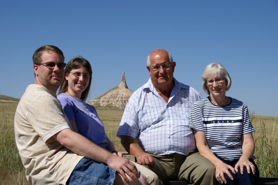 James, Julie, Gary, and Surella sit with a thin stone spire sticking into the sky beyond