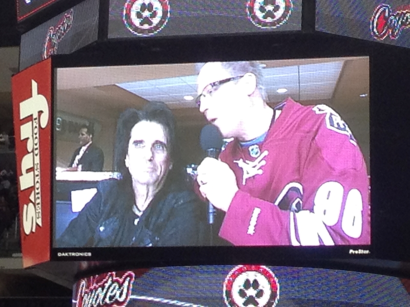 Singer Alice Cooper is interviewed on the big screen of an arena scoreboard