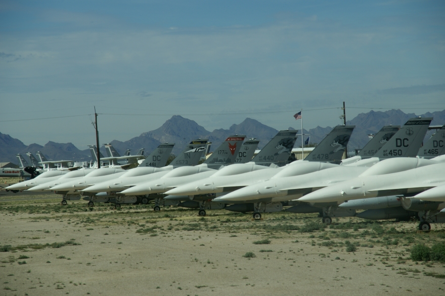 A row of fighter jets with protective white coating over the cockpits
