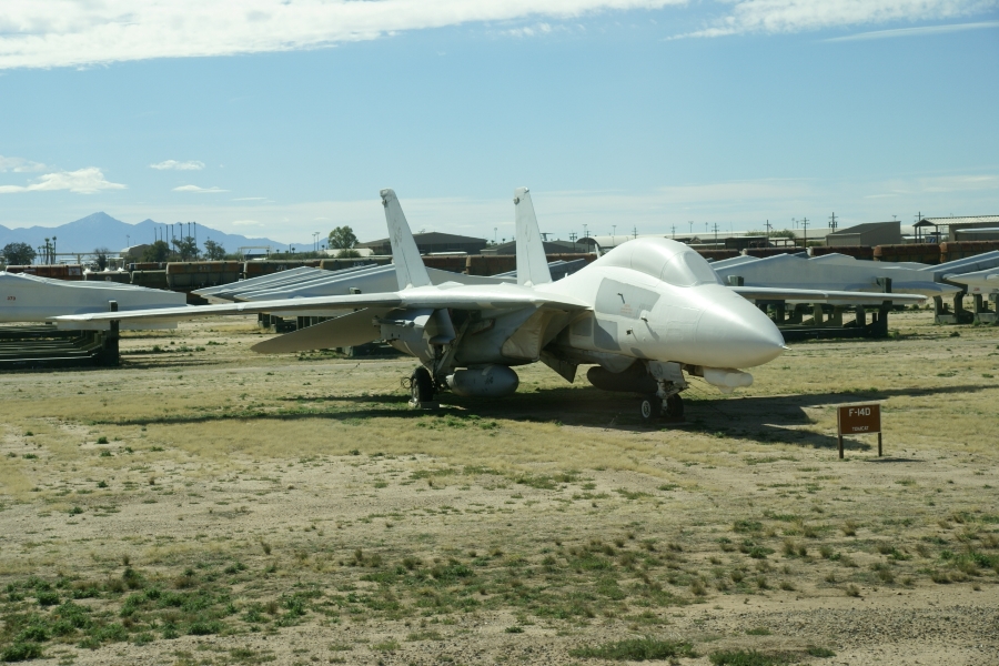 A large fighter jet with wings spread wide sits near the drive lane