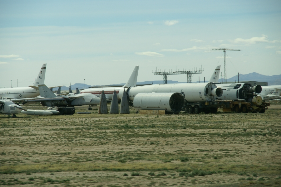 Several long tubular shapes with nozzles at one end set near a row of planes