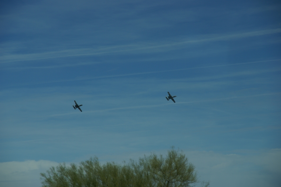 Two planes with engines on either side of the fuselage behind the wings bank through the sky shortly after takeoff