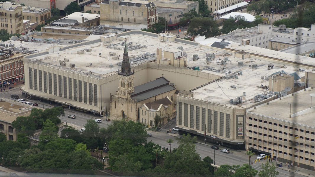 A multistory building wraps around a historic stone church