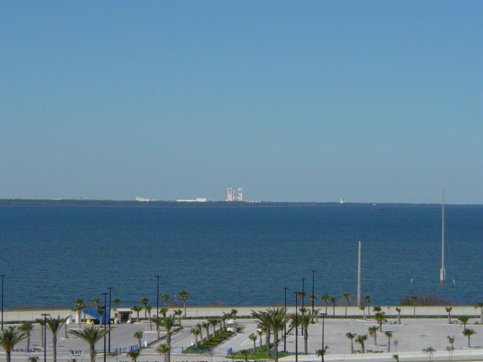 Large building rising above coastal brush