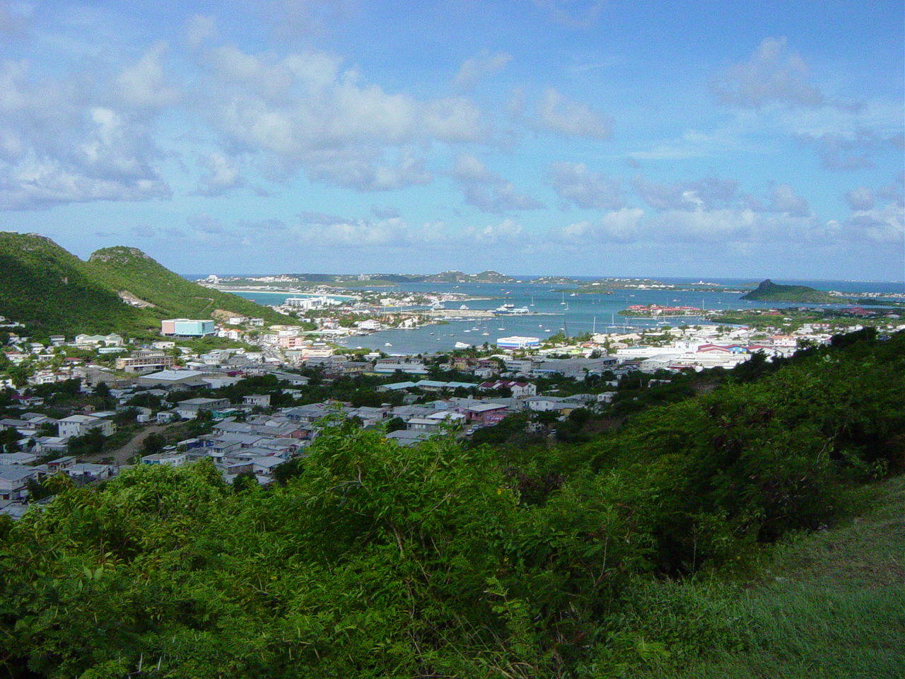 Green hills surround a blue inlet with houses built up all around