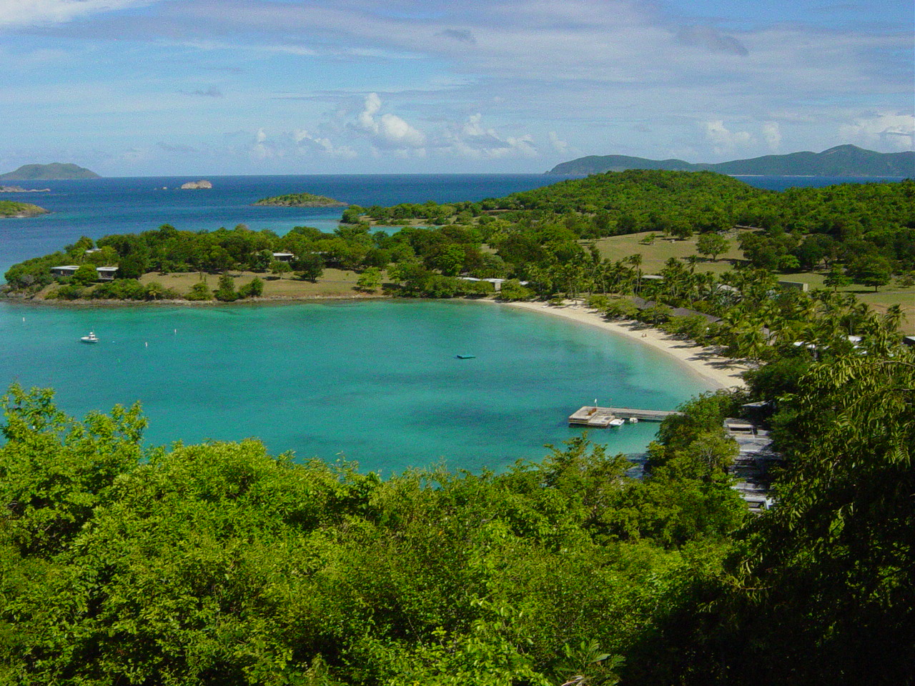 Clear blue water and a white sand beach in an undeveloped inlet