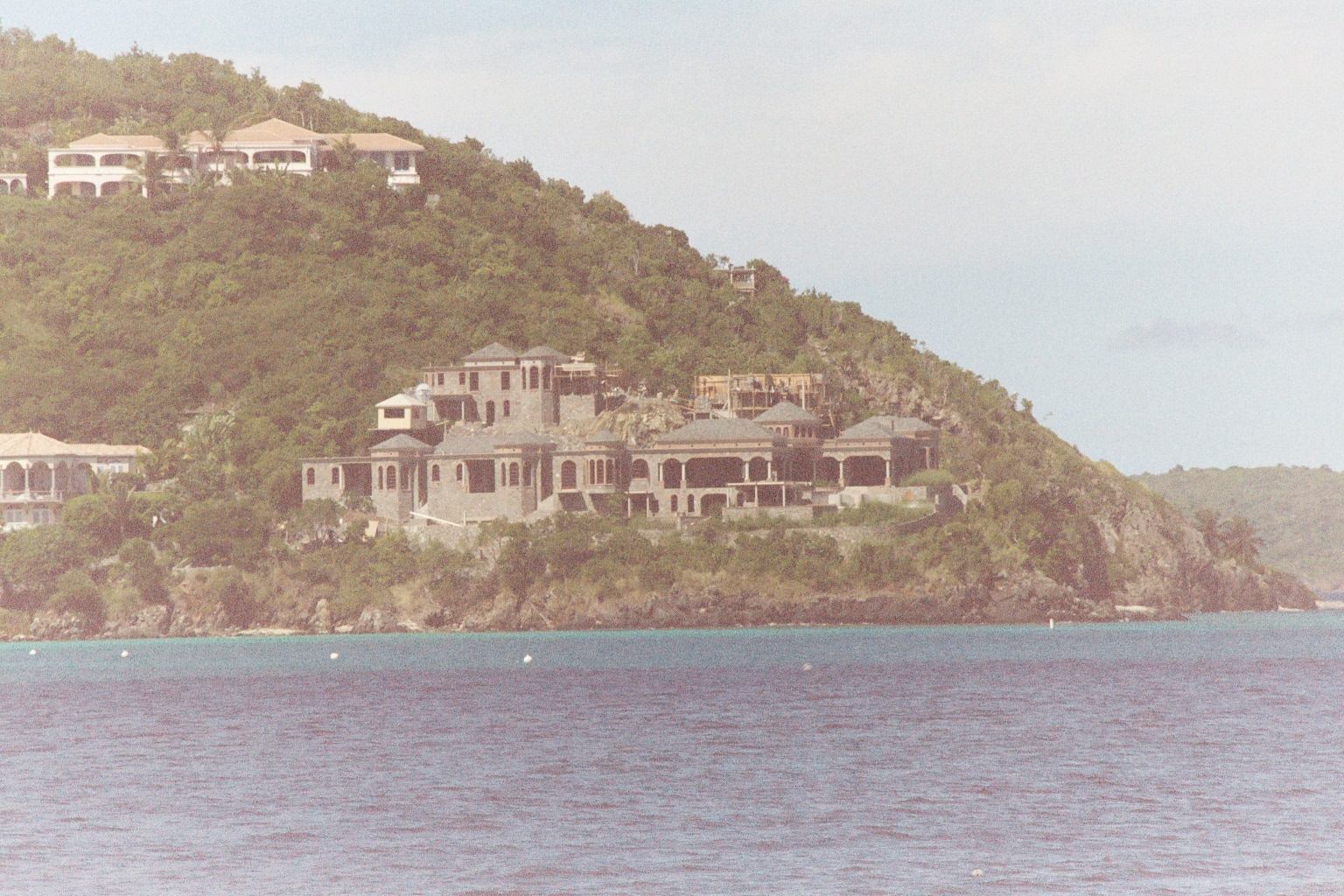 Very large house under cosntruction on a wooded hillside