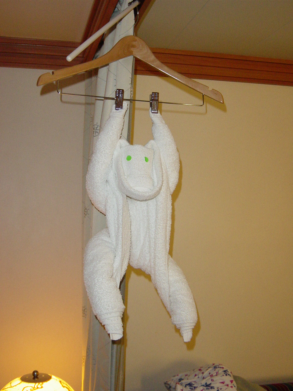 Folded towel monkey hanging from a clothes hanger