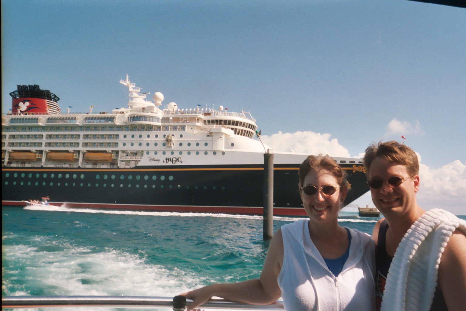 James and Julie on deck of boat with cruis ship in background