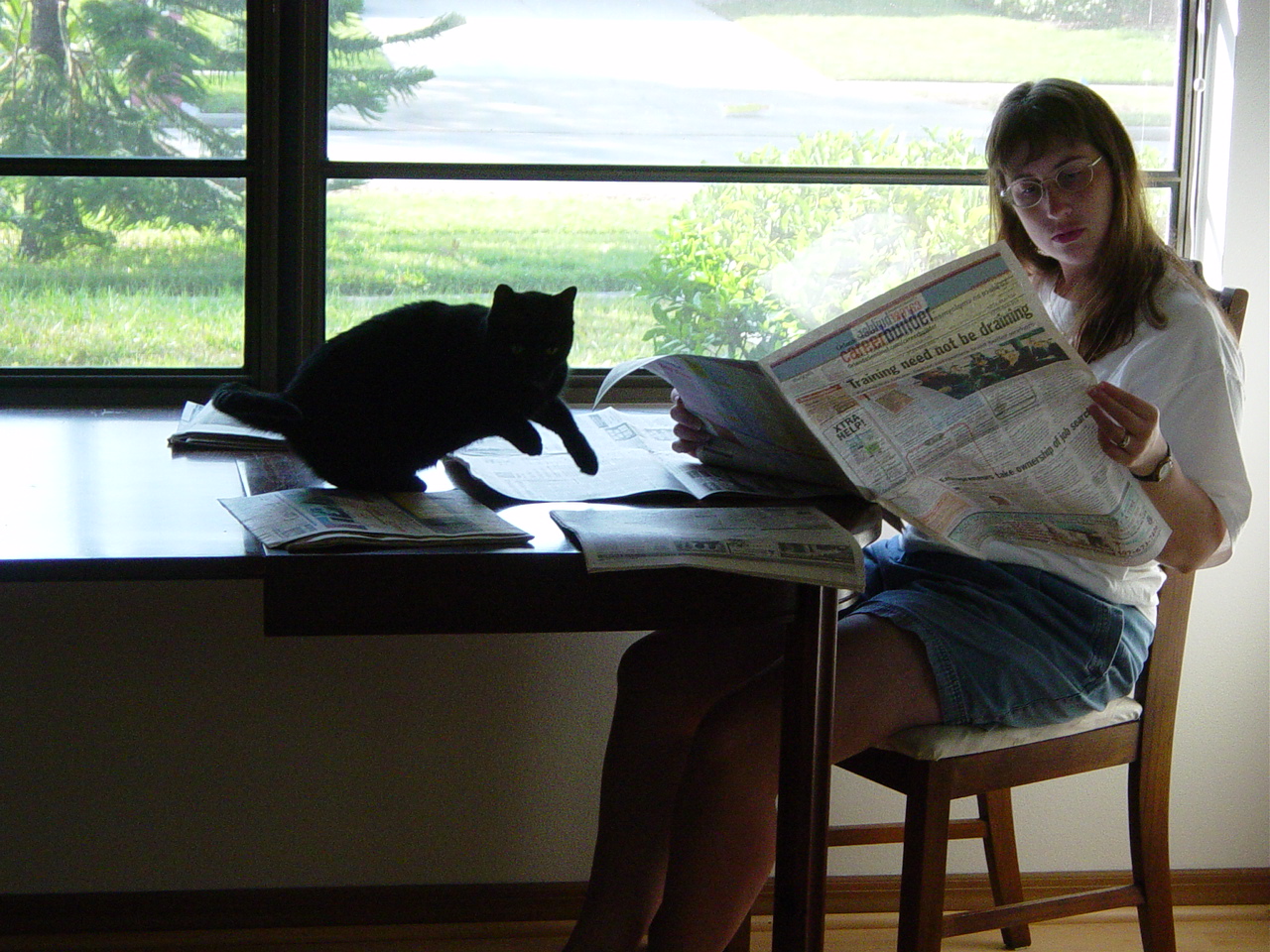 Julie at table with cat on newspaper