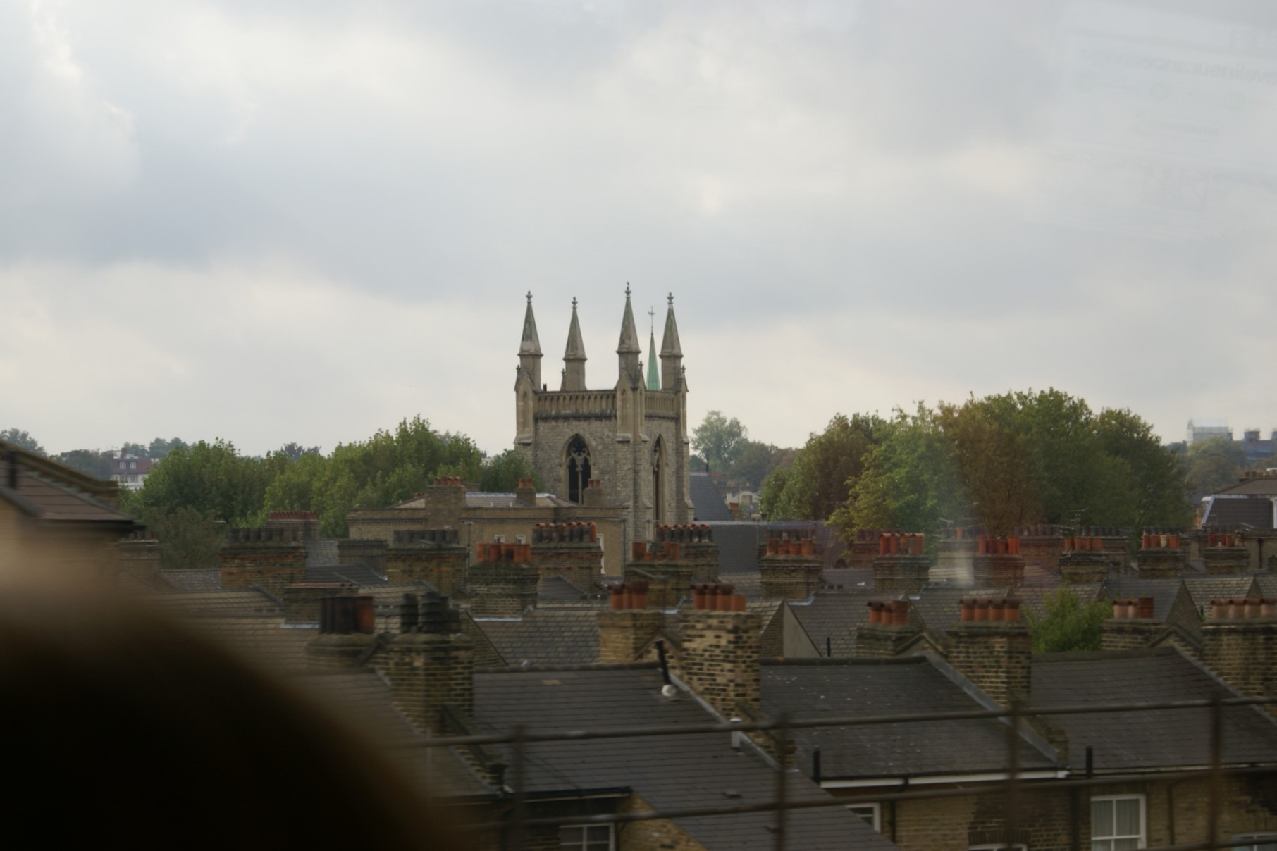 Tan brick church tower above roofs
