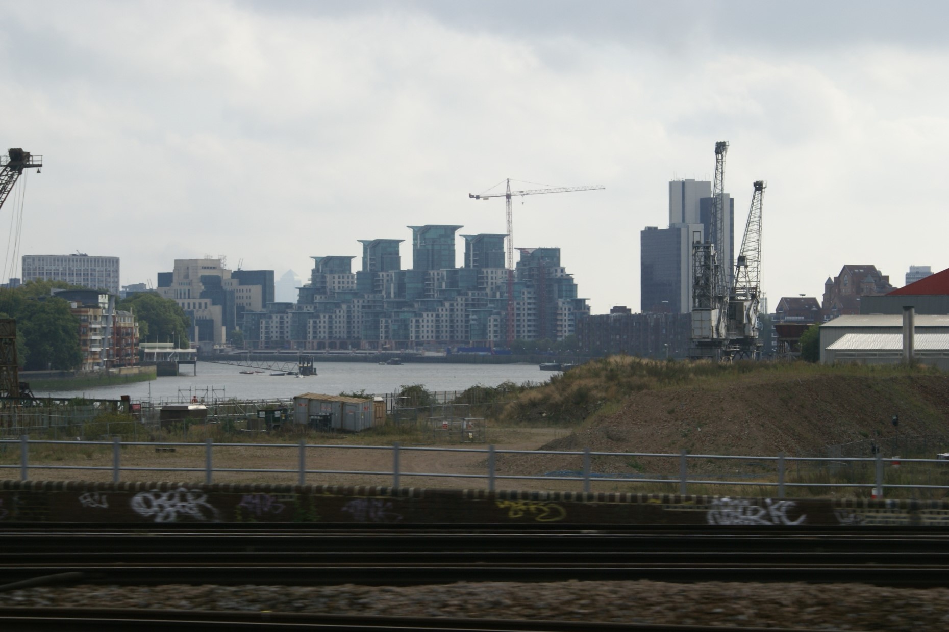 Tall buildings line a river's banks