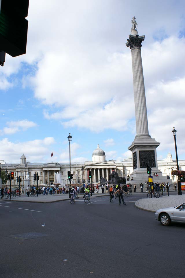 A white monolith with a statue on top stands in the middle of a large square