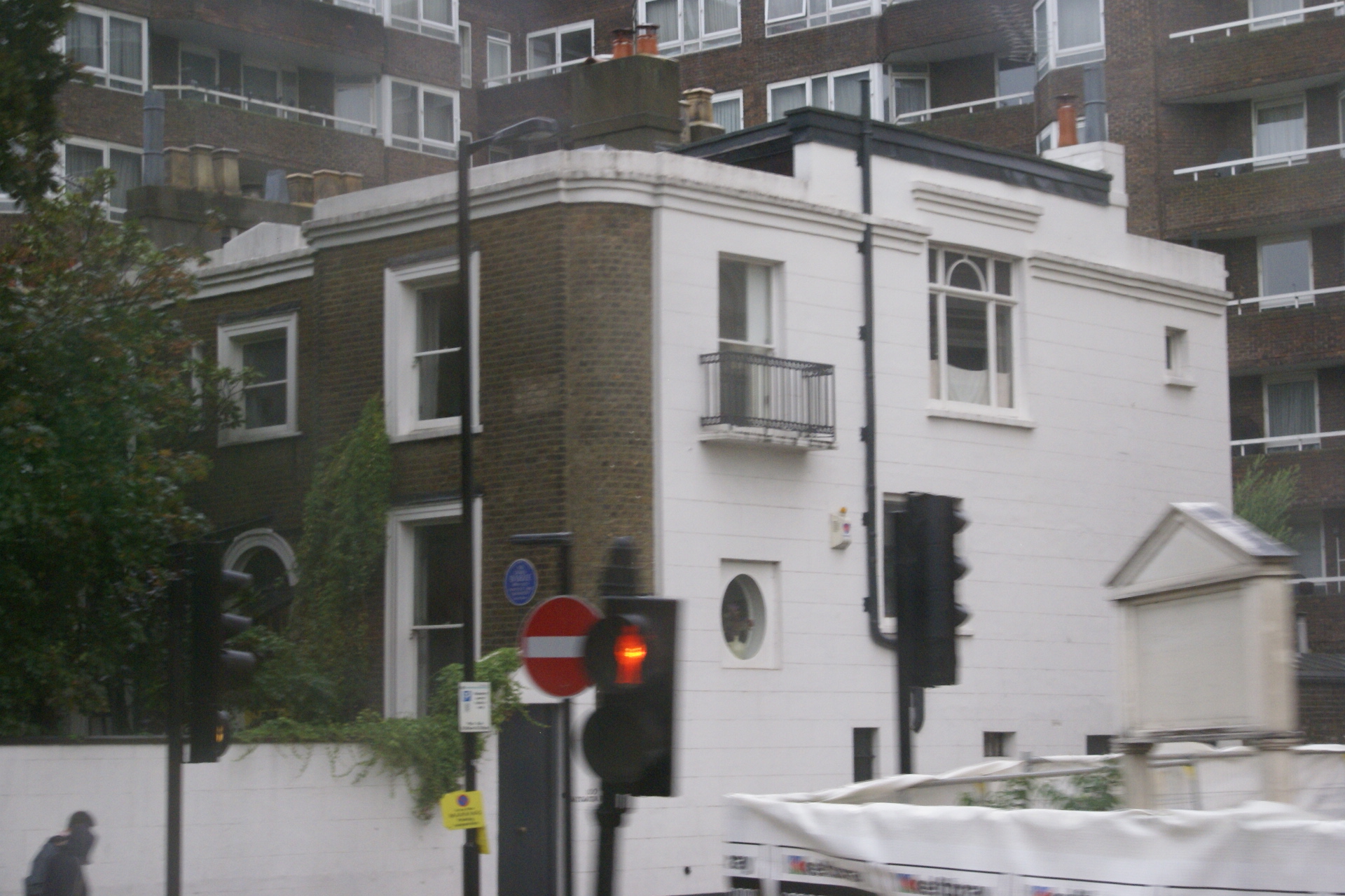 Three story house with brick front and blue plaque