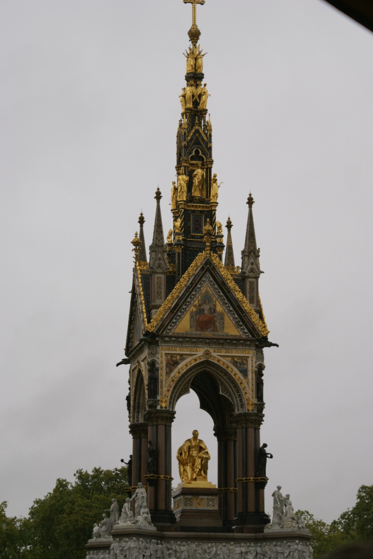 Gold statue standing in gold and black stone monument