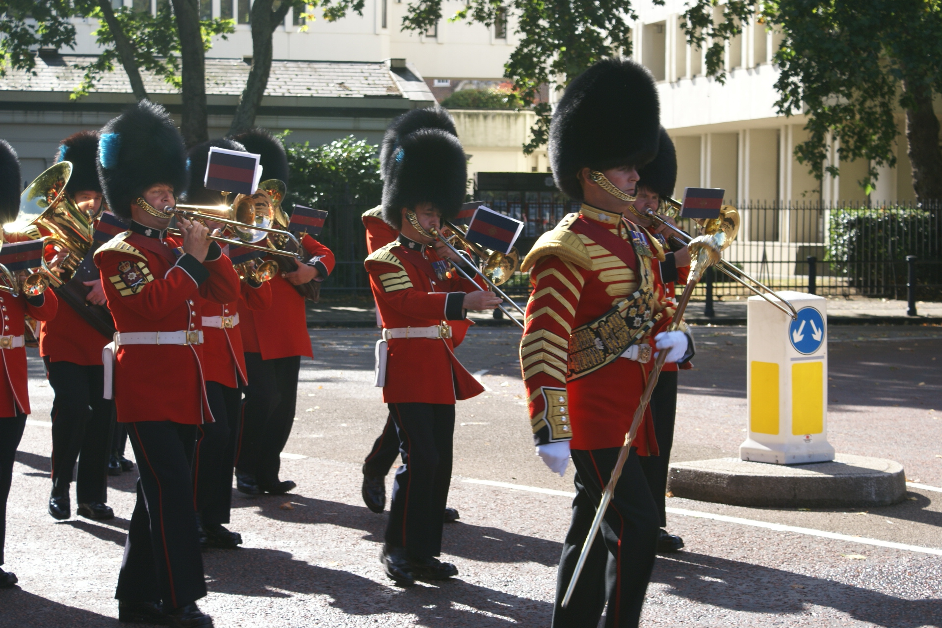 Marching band members in red military uniforms with tall black fluffy hats