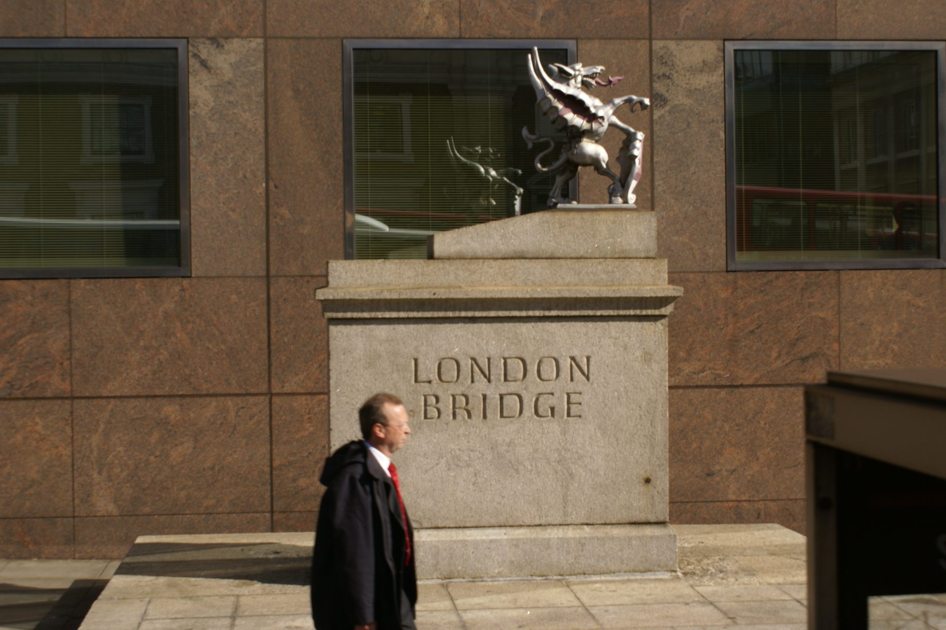Stone sign reading London Bridge with griffin sculpture on top
