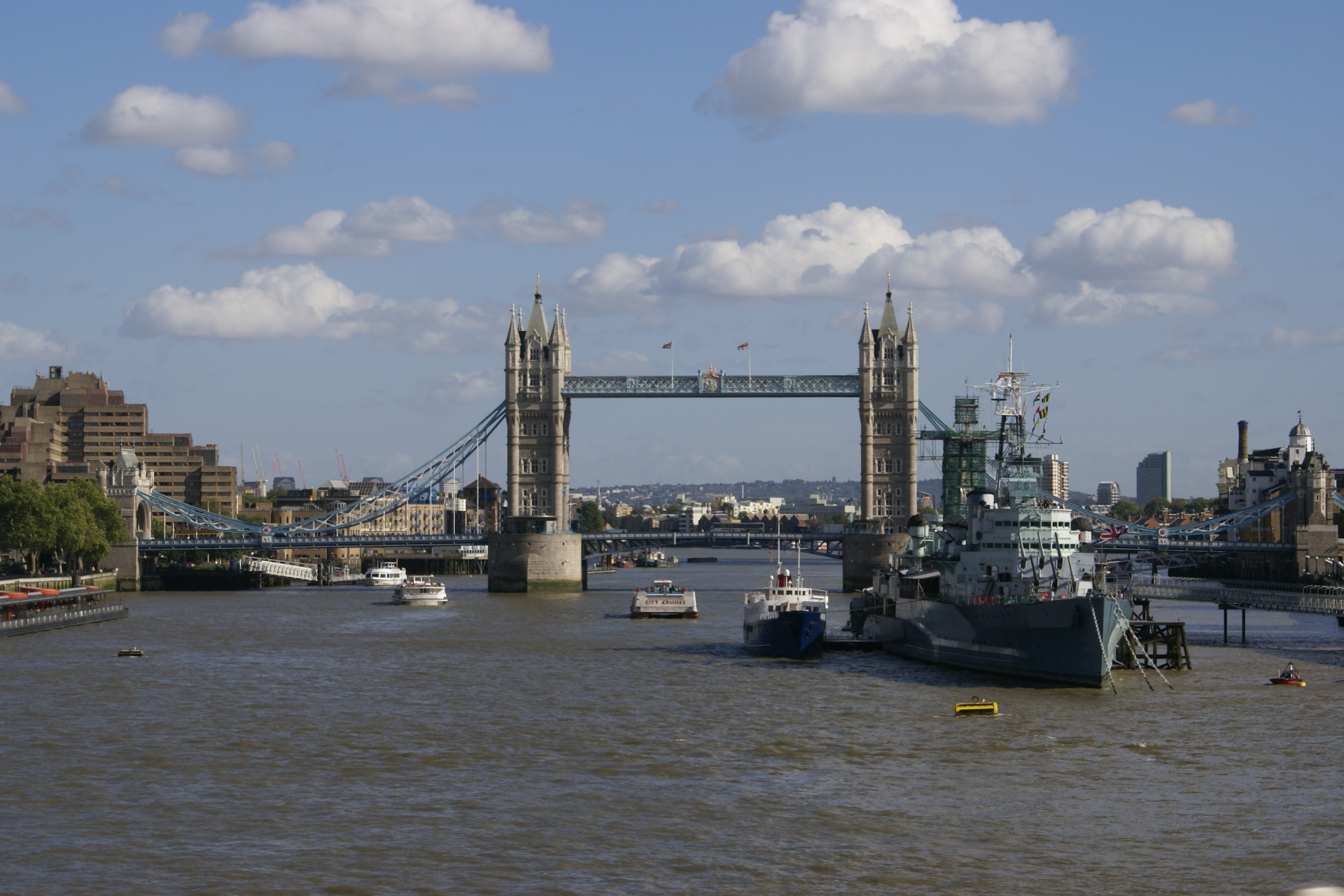 Two tan stone towers support a draw bridge over a river