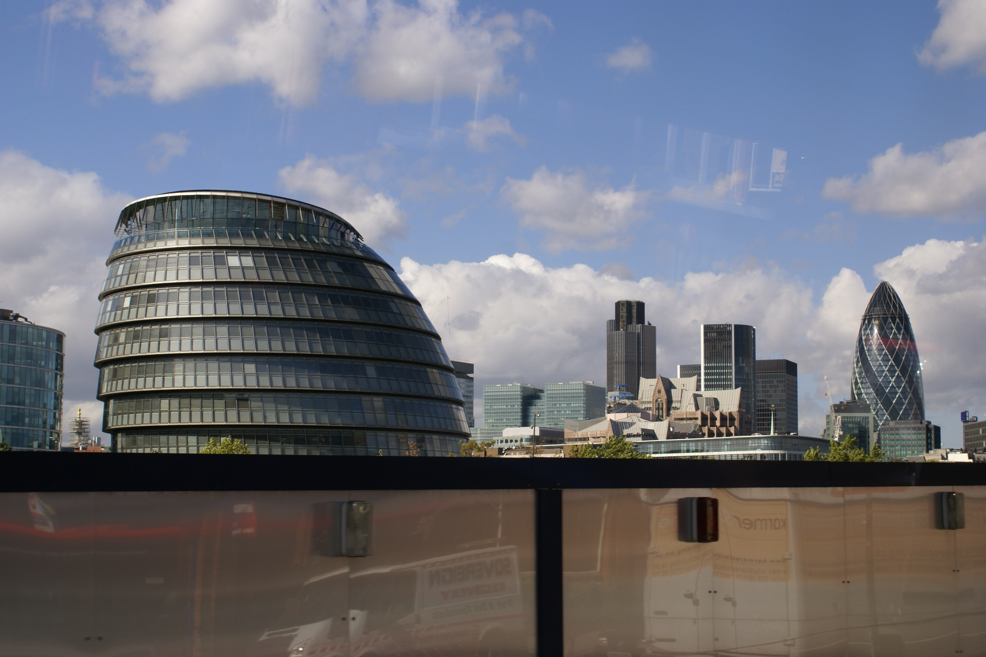 Ovoid glass building in foreground with bullet shaped high rise in distance