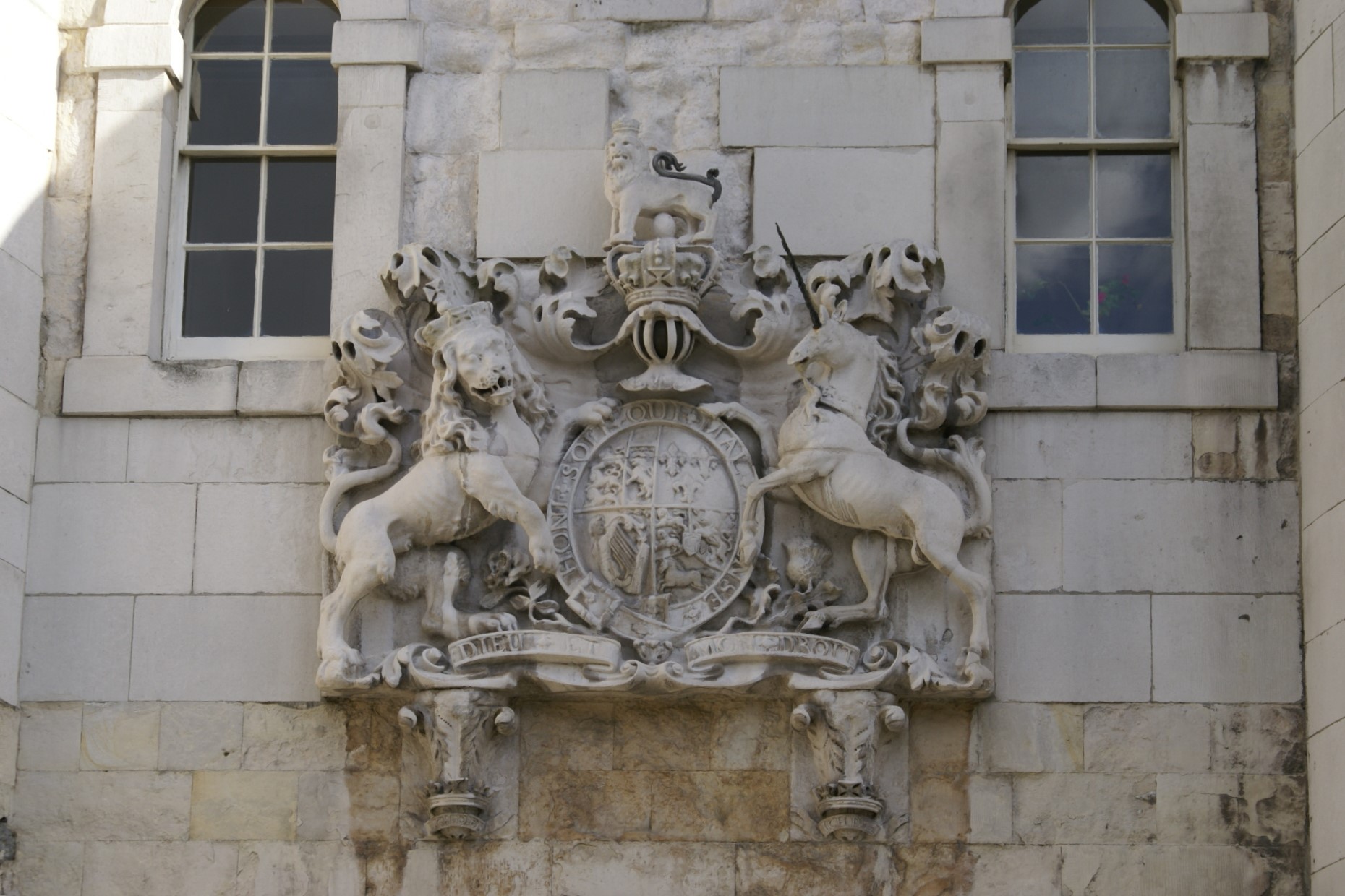 Stone carving of the Royal Crest of Great Britain on a white stone wall