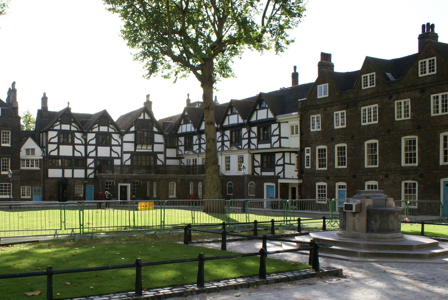 Tudor style buildings with blue doors and on duty Royal Guards