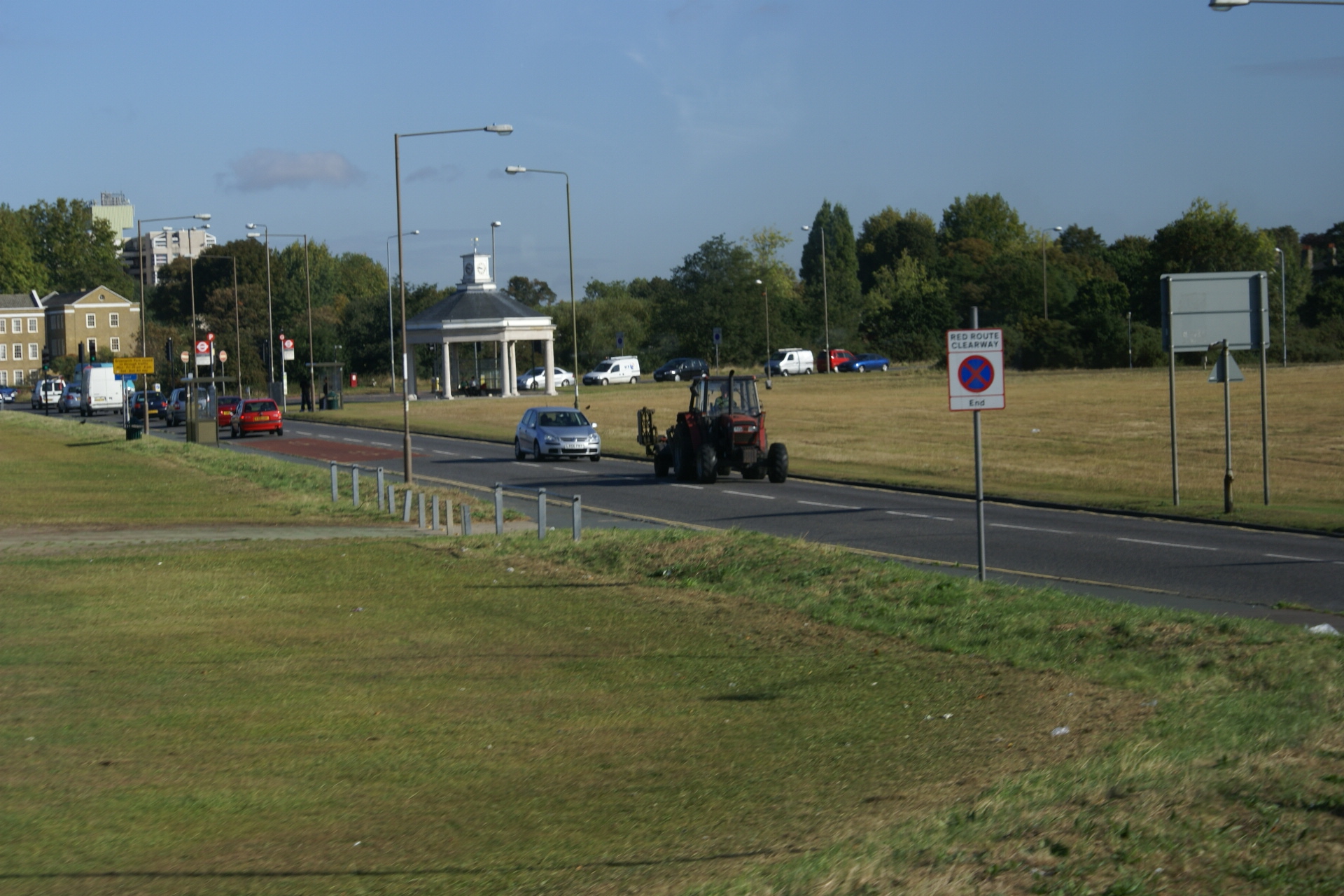 A tractor drives down the road on the edge of town