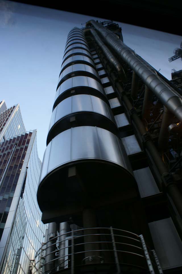 Stainless steel panels wrap a curving stair next to exposed ductwork going up over 10 stories