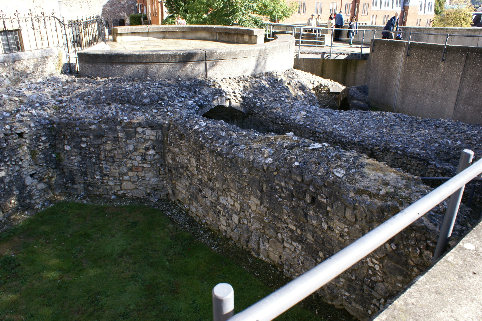 Thick stone walls stand above the grass where they’ve been uncovered amongst other structures