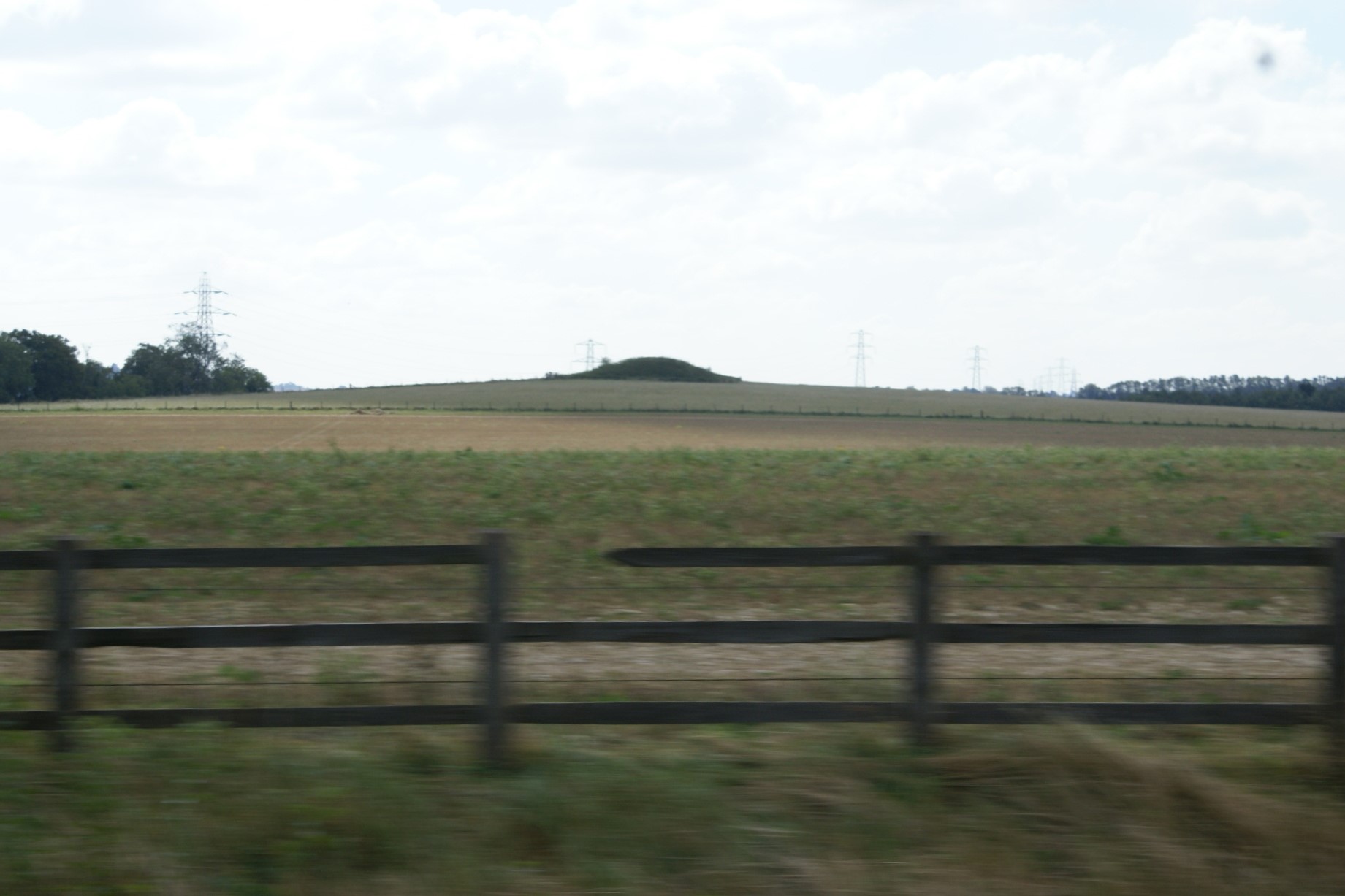 A dark green mound abruptly sticks up above crop fields