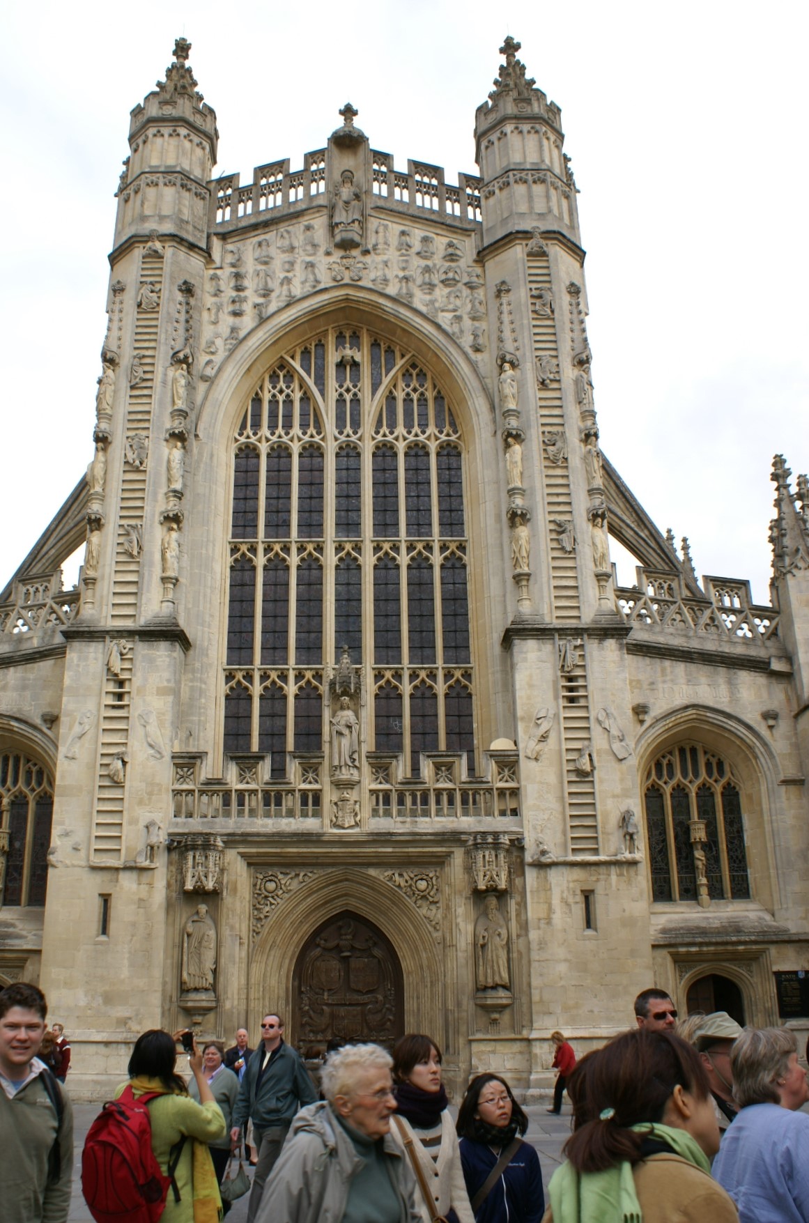 Stone church front with ladders on either side of the main entry showing creatures climbing to heaven