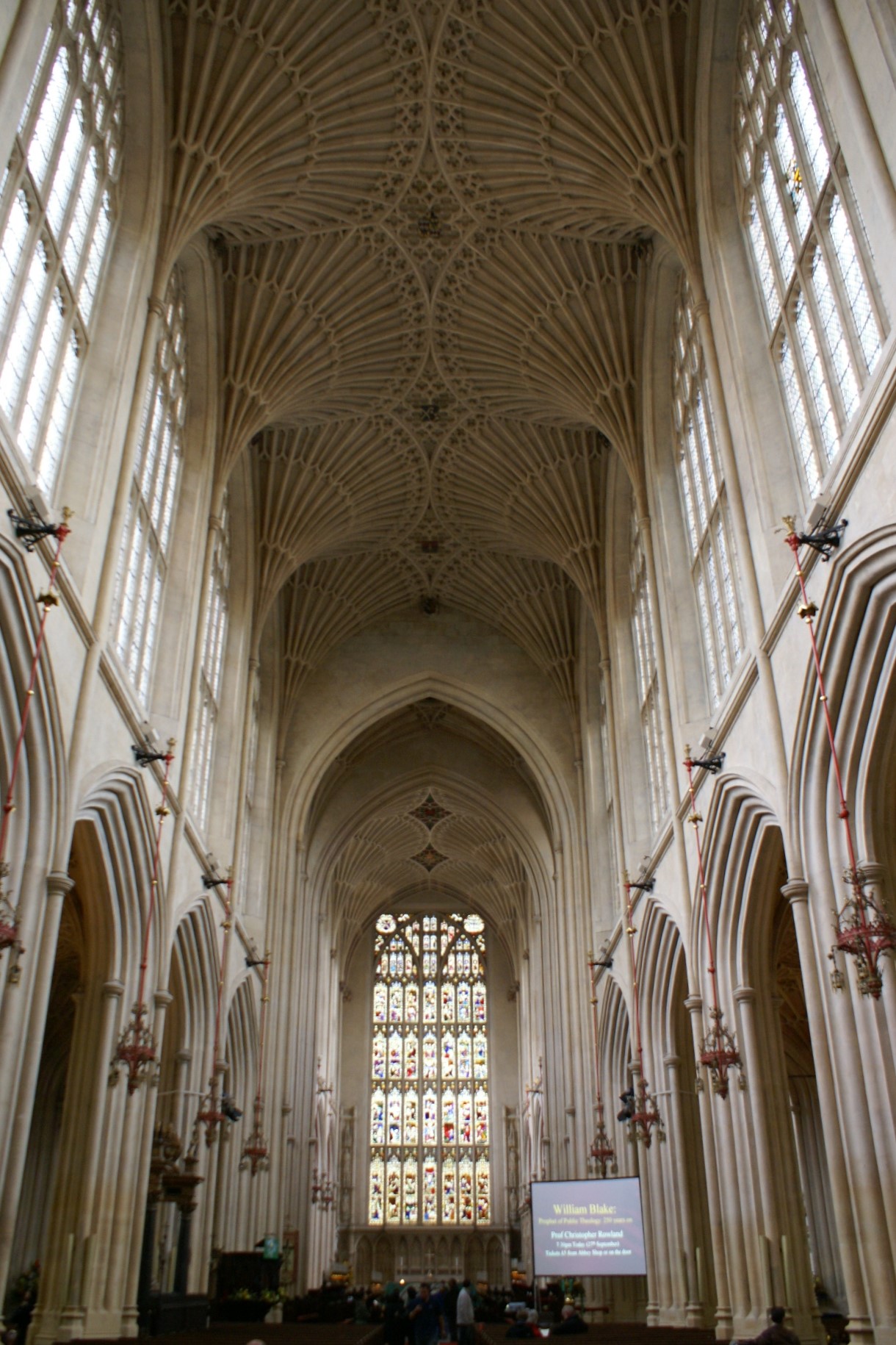 A ceiling of intricately carved white stone above large clear windows stands 30 or 40 feet above the floor of the church